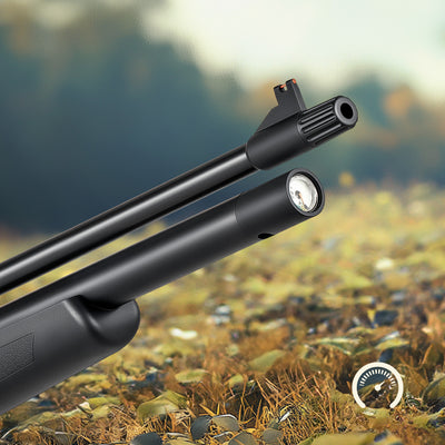 Close-up of a black rifle barrel with a scope against a natural background