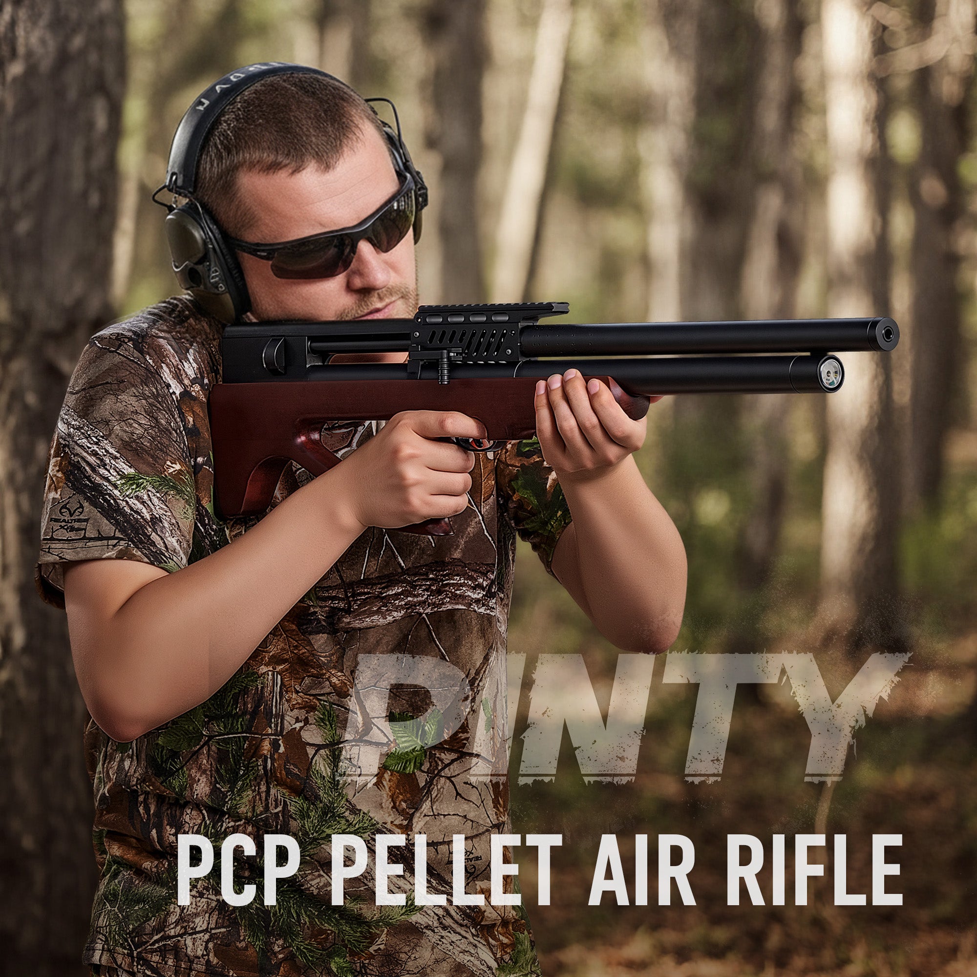 Man in camouflage holding a PCP pellet air rifle in a forest setting with 'Pinty' branding.